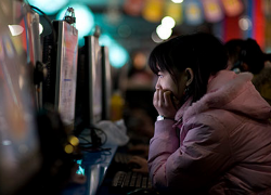 A woman sits in a cybercafé in Beijing. Photo: Dan Chung/The Guardian