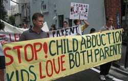 Demonstrators hold a sign advocating dual custody rights for divorced parents in Japan.